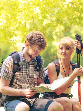 Hikers backpackers couple reading map on trip.