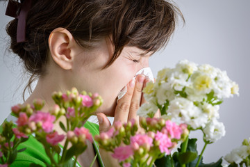 Obraz na płótnie Canvas Woman with handkerchief and pollen allergy near flowers