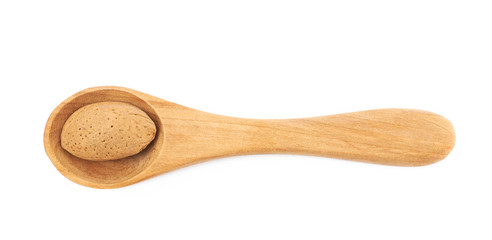 Almond nut in a wooden spoon isolated