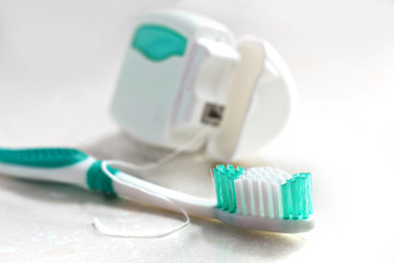 Toothbrush and dental floss on white background.