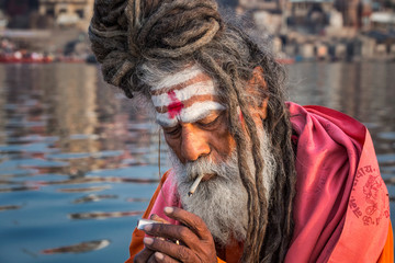 Portrait of sadhu smoking in the boat, Varanasi, India.