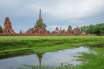 Fototapeta premium Ruins of buddha statues and pagoda of Wat Mahathat in Ayutthaya historical park, Thailand