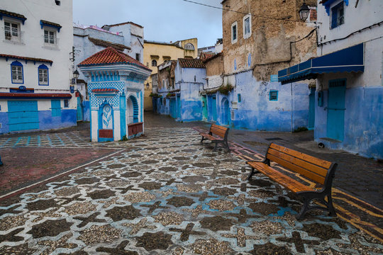 Mosaic square with benches and a small pavilion in a blue city