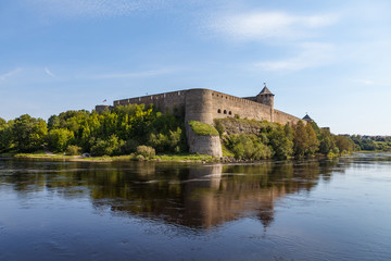 Naklejka premium Ivangorod medieval fortress on the river Narva, Estonia and Russia border. Summer day view.