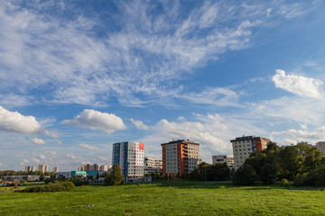 New modern blocks of flats in green area with blue sky at summer day. Northern friendly style.