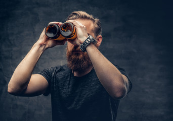 A man looking throught beer bottles.