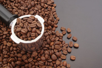 Coffee machine portafilter and roasted arabica coffee beans on table, espresso coffee concept