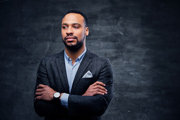 Fototapeta premium A luxury black male dressed in a suit over grey vignette background.
