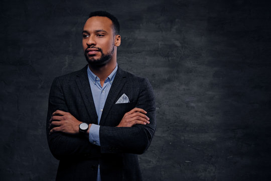 A Luxury Black Male Dressed In A Suit Over Grey Vignette Background.