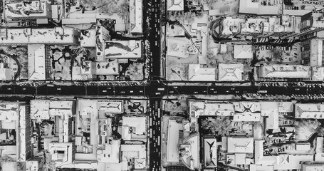 The city is covered with snow. Urban landscape. A view from above of a city crossroad in winter. Cross.
