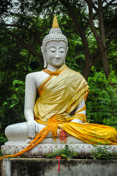 White Buddha Image in garden of Buddhist temple.