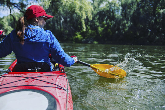 A girl rafts down the river on a kayak.