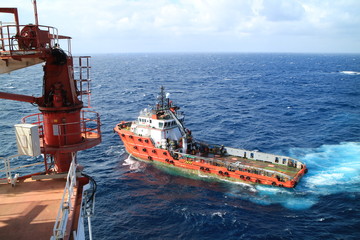 Fototapeta premium Supply boat transfer cargo to oil and gas industry and moving cargo from the boat to the platform