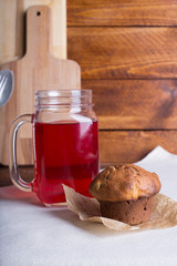 Fresh and healthy red Fruit juice drink  in a glass and jug and muffin or cake on the wooden brown table background. Side view.