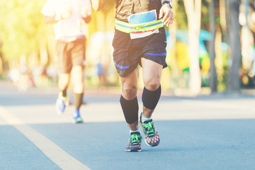 Fototapeta premium Runner legs between running in marathon competition in the city road.