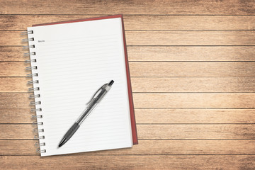 notebook with pen on old wooden texture background