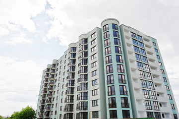 Fototapeta premium Balcony of new modern turquoise multi storey residential building house in residential area on sunny blue sky.