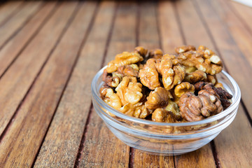 Walnuts in bowl over wooden background
