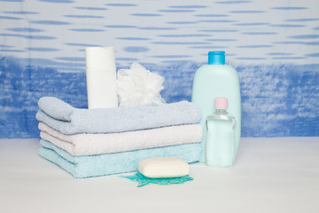 Bath towels, soap, wisp of bast, shower gel, Towels folded stack. The pieces of soap lying in front of a towel. Soap and towels are needed for hygiene and purity of the body. Bathroom accessories.