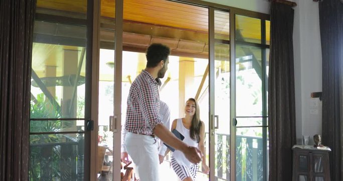 Real Estate Agent Showing Couple Modern Apartment, Businessman Opening Door Presenting House Interior To Buyers Excited Man And Woman Holding Hands Slow Motion 60