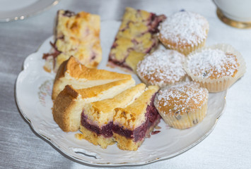 Kuchenplatte mit Stücken von Käsekuchen, Muffins, Zwetschenkuchen und Kirschkuchen