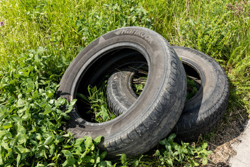 Two old damaged tires are on the road.