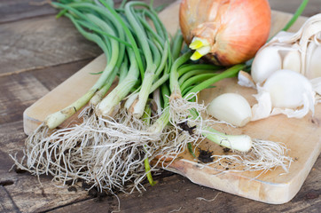 Cebollas y ajos sobre fondo de madera
