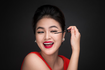 Obraz premium Make-up and cosmetics concept. Asian woman doing her makeup eyelashes black mascara.
