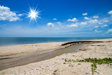 Blue sky and small channel on the beach with sun.