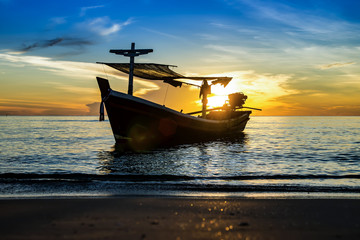 Silhouettes of Fishing boat on the beach.