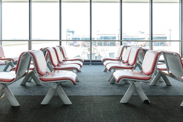 Departure lounge with empty chairs in the terminal of airport, waiting area