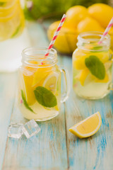 lemonade with mint on rocks served in jar with a straw