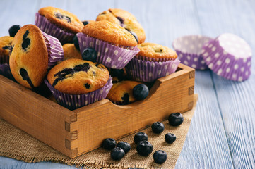 Homemade blueberry muffins on wooden background.