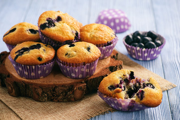 Homemade blueberry muffins on wooden background.