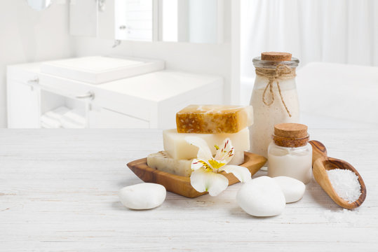 Spa products on wooden surface over blurred bathroom sink background