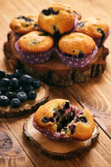 Homemade blueberry muffins on wooden background.