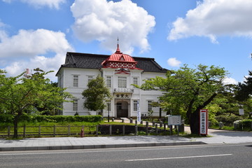 大宝館（山形県鶴岡市）／ 大宝館は、大正天皇の即位を記念して、大正４年(1915)に建てられた、赤いドームと白壁が特徴の、完成度の高い擬洋風建築です。開館当初は、物産陳列場、戦後は市立図書館として利用されていました。現在は、明治の文豪・高山樗牛や、日本のダ・ヴィンチといわれた松森胤保、昭和初期の日本の代表作家・横光利一など、鶴岡が生んだ先人たちの偉業を讃える資料を展示しています。