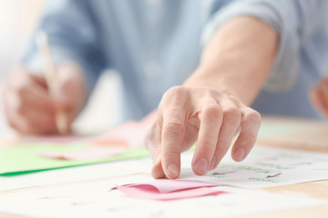 Male hand taking color sticker from table, closeup