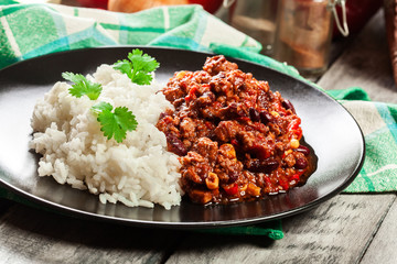 Hot chili con carne with ground beef, beans, tomatoes and corn served with rice