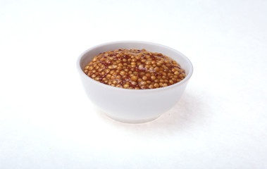 Typical french dijon rough mustard in bowl from isolated on white background