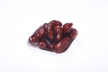 Delicious dried organic dates on bowl isolated over white background.