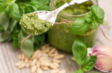 pesto sauce inside glass jar with fresh raw ingredients