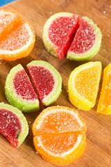 Colorful jelly candies on the wooden board background.