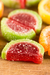Colorful jelly candies on the wooden board background.