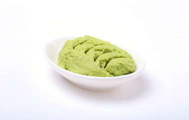 Bowl with wasabi isolated on white background.