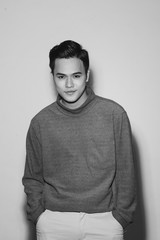 Young asian man's portrait against black background