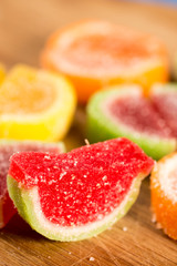 Closeup macro above colorful jelly candies on the wooden board.