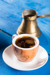 Flat lay above cup of coffee on the blue background table.