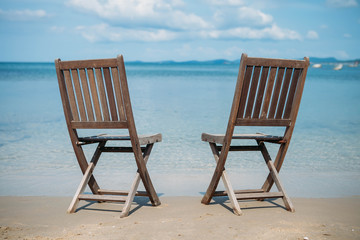 Two beach chairs on tropical shore