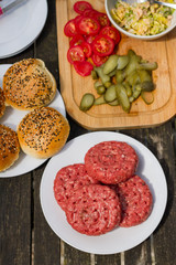 Barbecue, BBQ in the garden. Ingredients. Fresh burger with beef on wooden table.